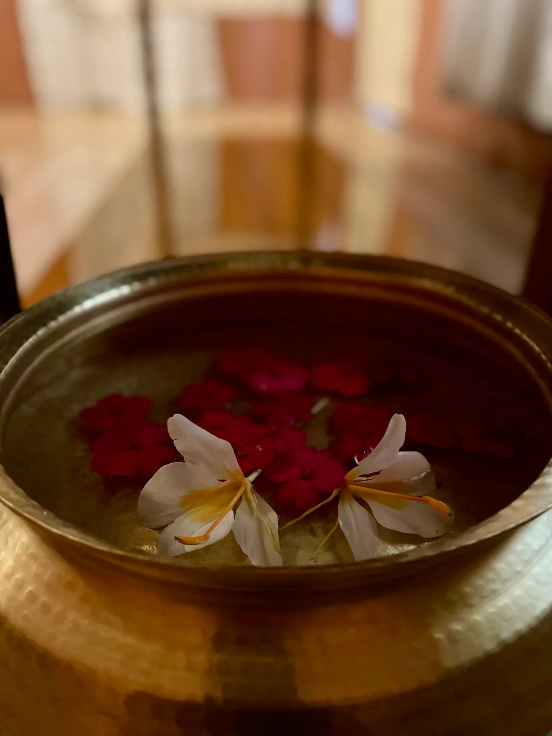 Flower petals floating in a brass bowl