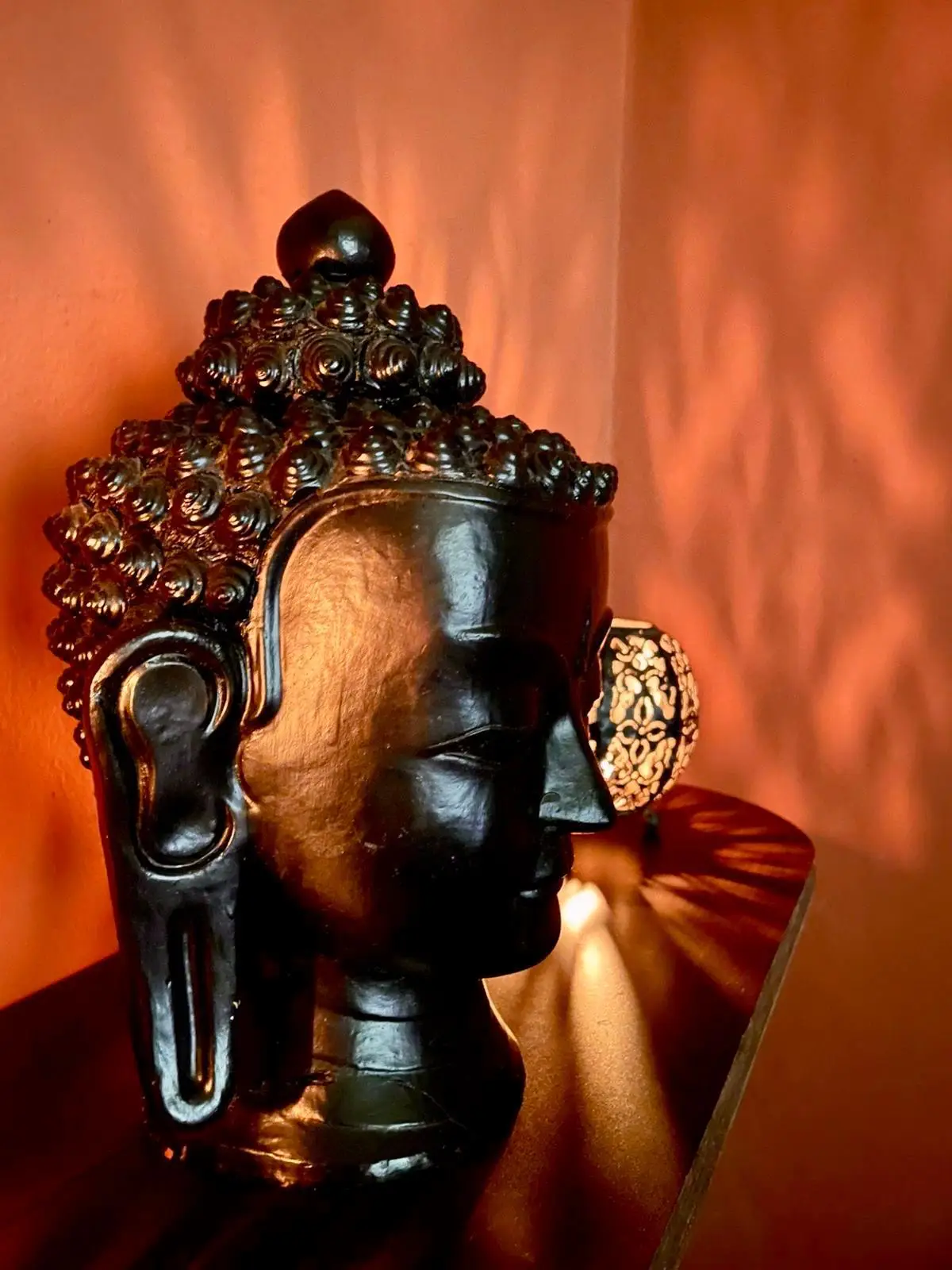 Buddha head sculpture in warm lamp light