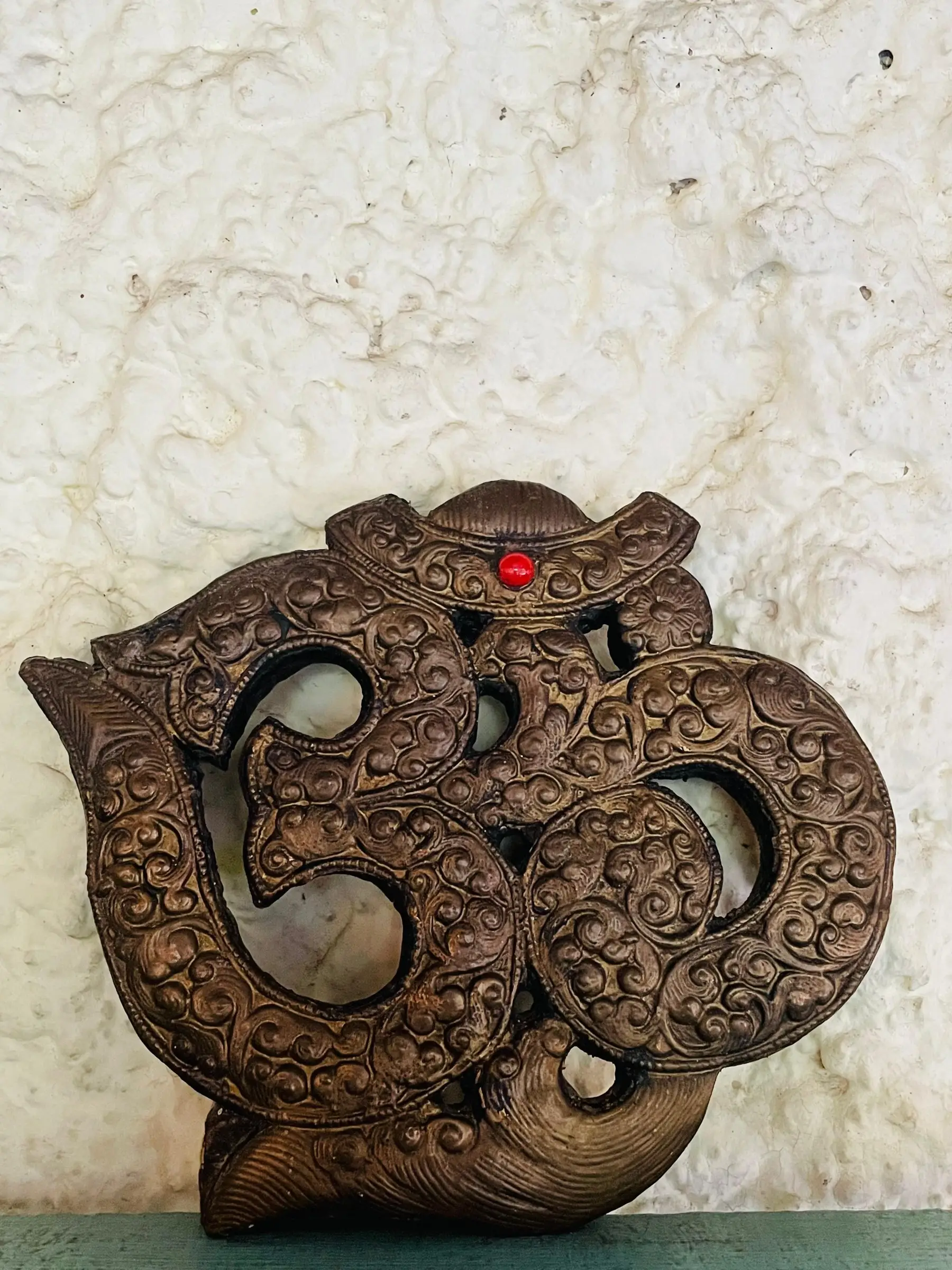 Traditional carved Om decoration on a wall at Jiva Spa