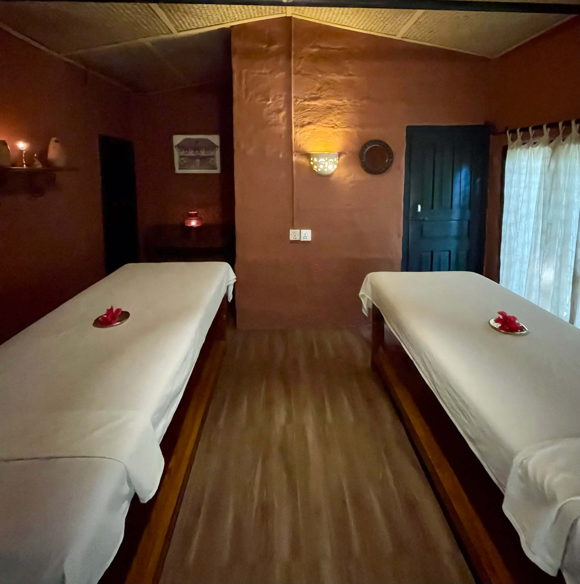 Couples treatment room with two massage beds in candlelight