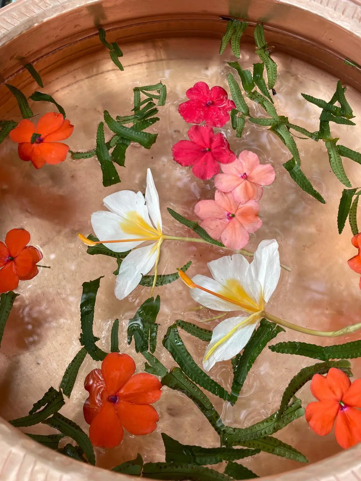 Fresh flowers floating in a copper bowl