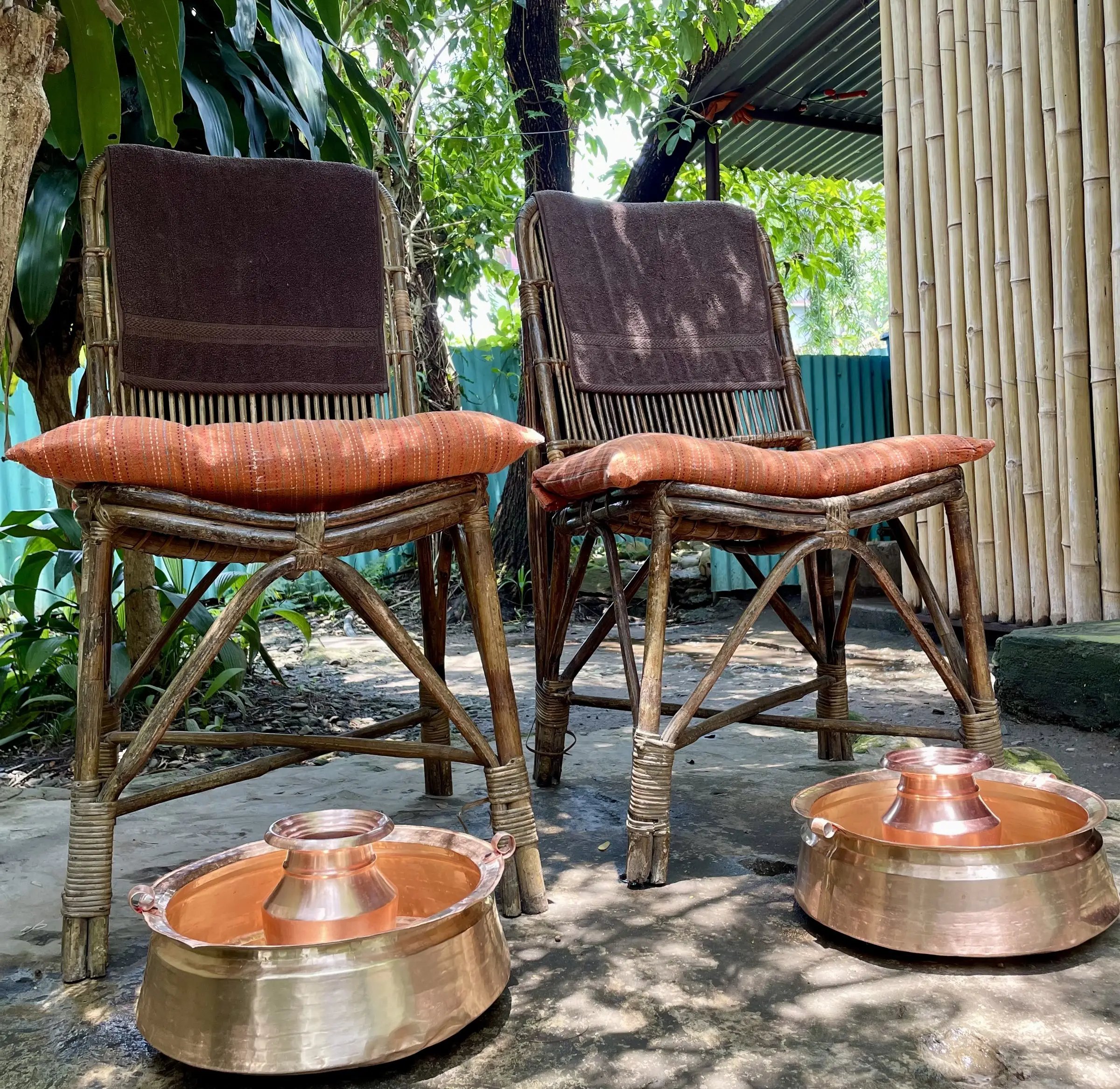Two garden chairs prepared with copper bowls for a foot ritual