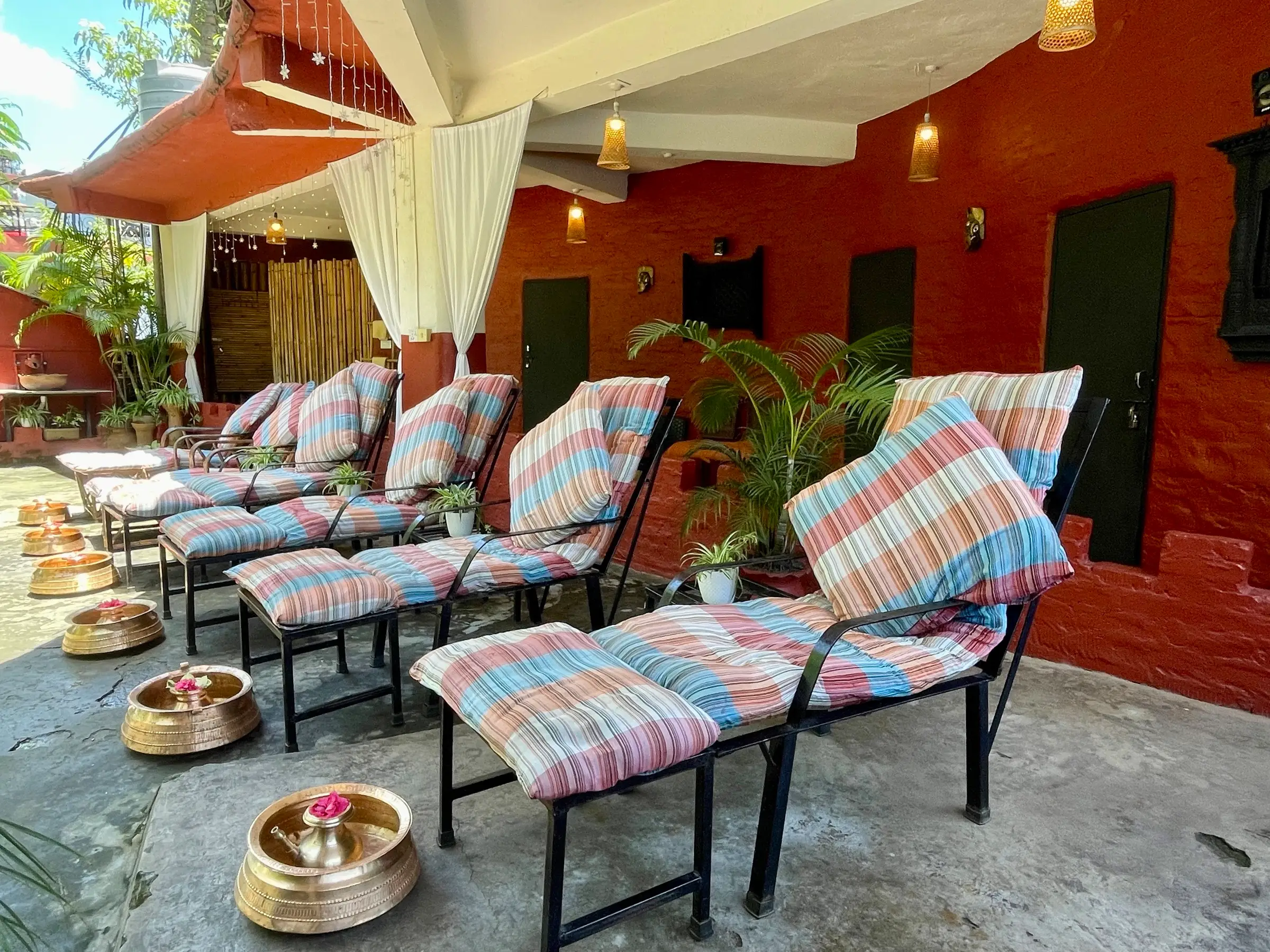 Covered terrace with reclining chairs and brass foot bowls