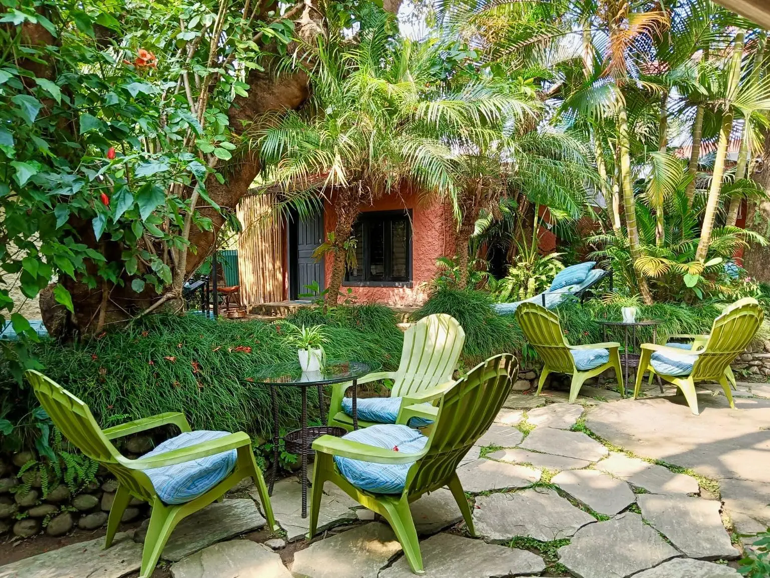 Garden courtyard with green chairs among tropical plants at Jiva Spa