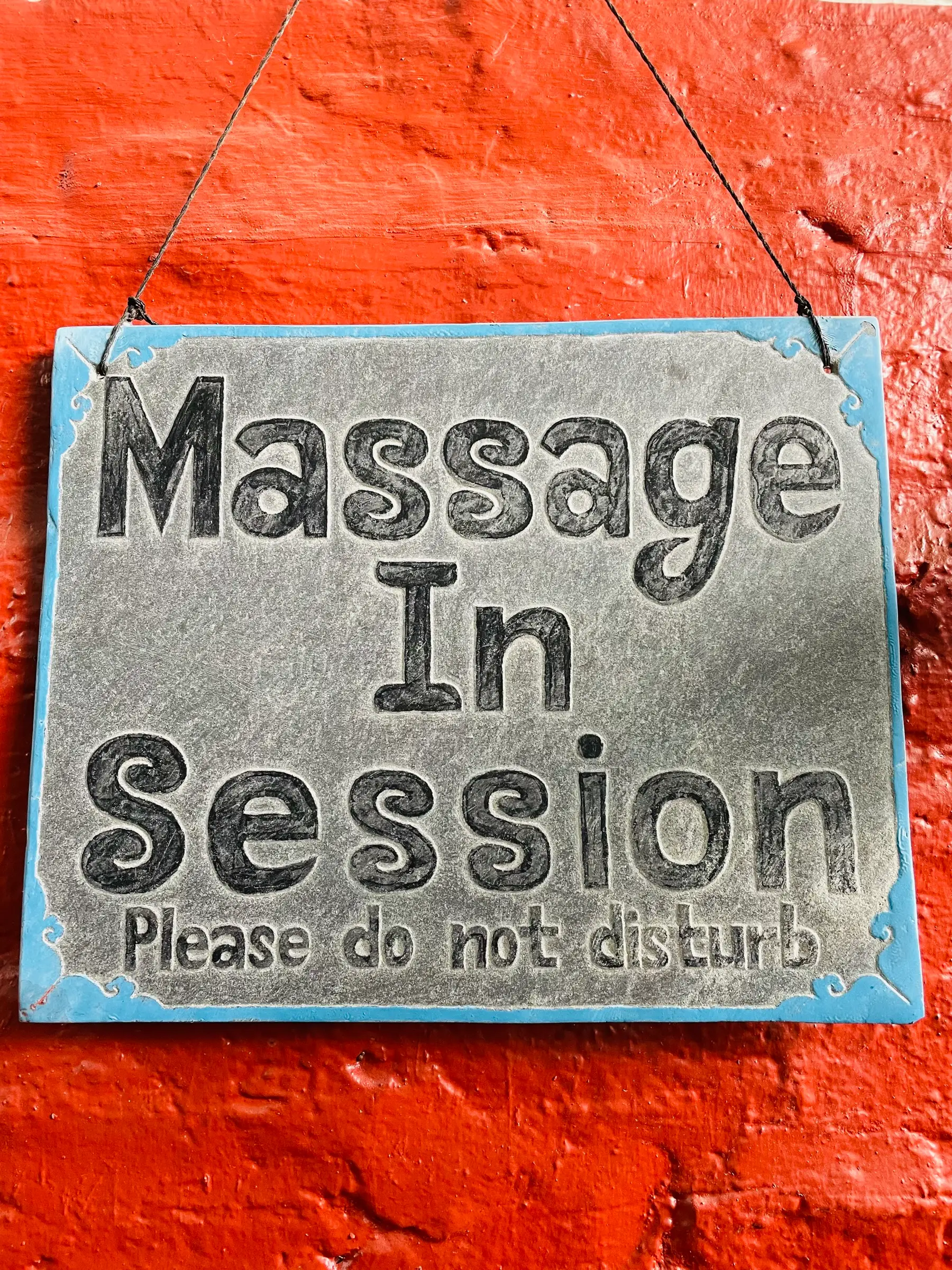 Hand-painted slate sign reading Massage In Session, please do not disturb