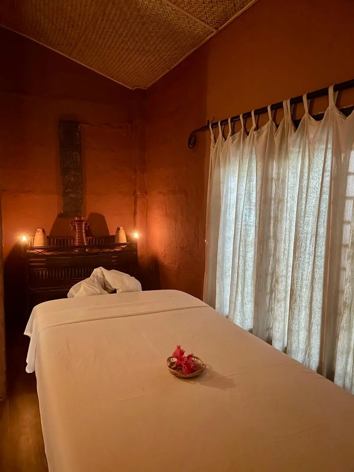 Treatment room with white curtains and candlelight