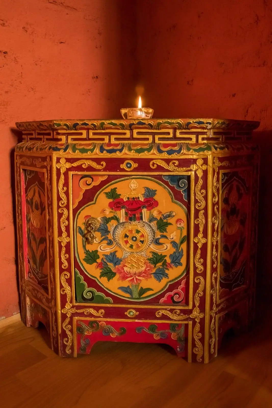 Hand-painted traditional cabinet with a lit candle