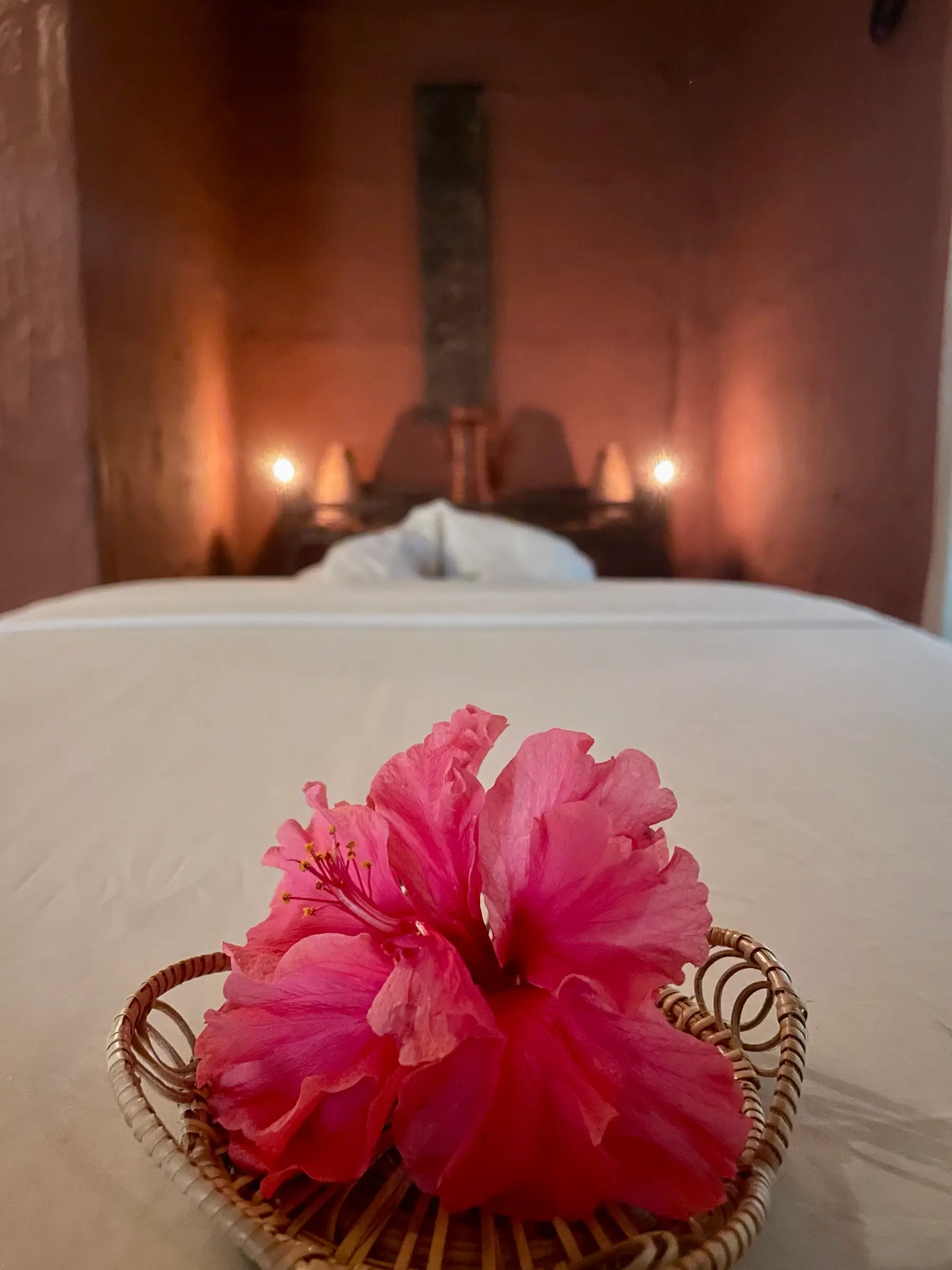 Treatment bed with hibiscus flowers and candles